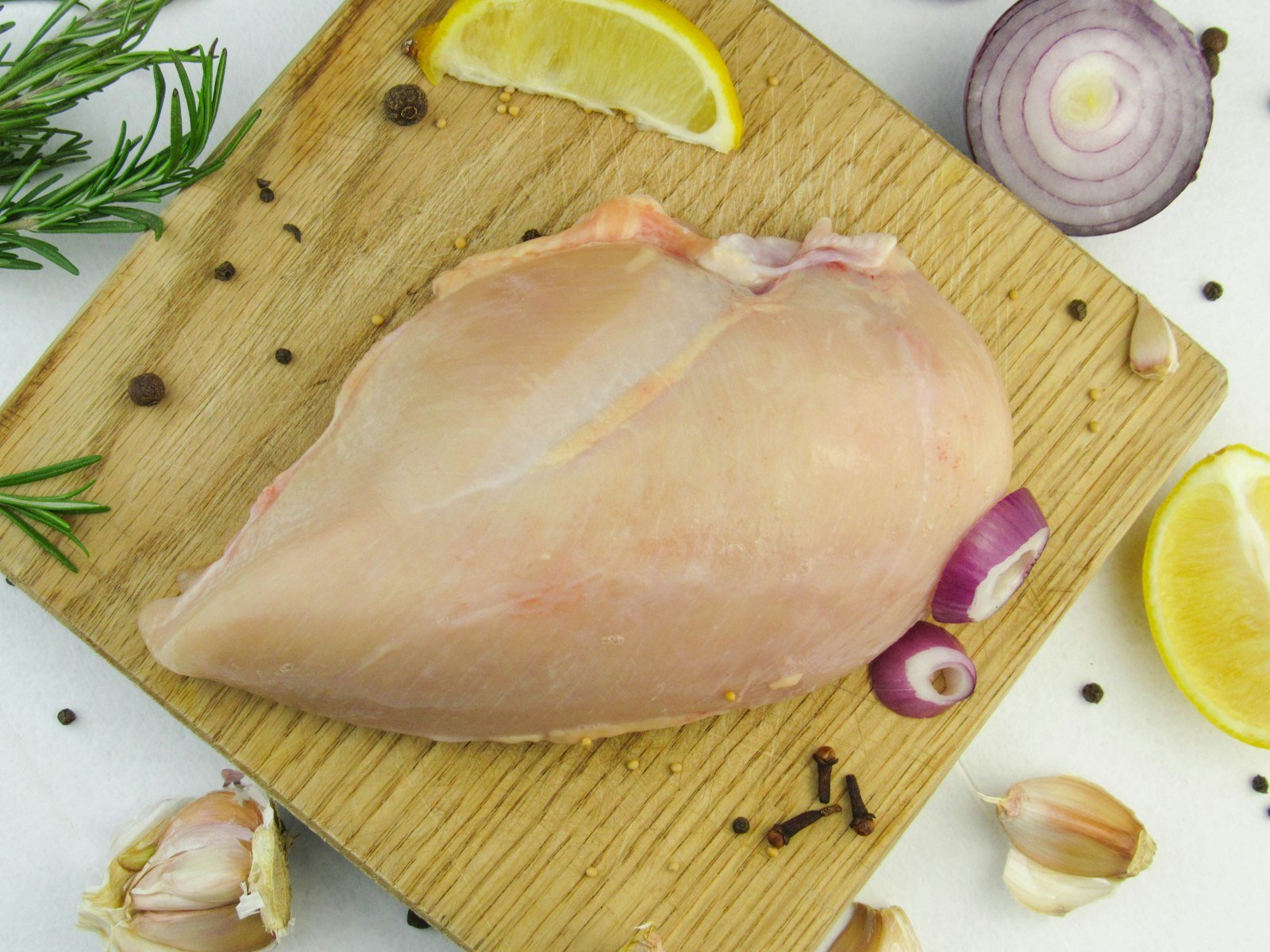 Raw chicken breast fillet with lemon and garlic